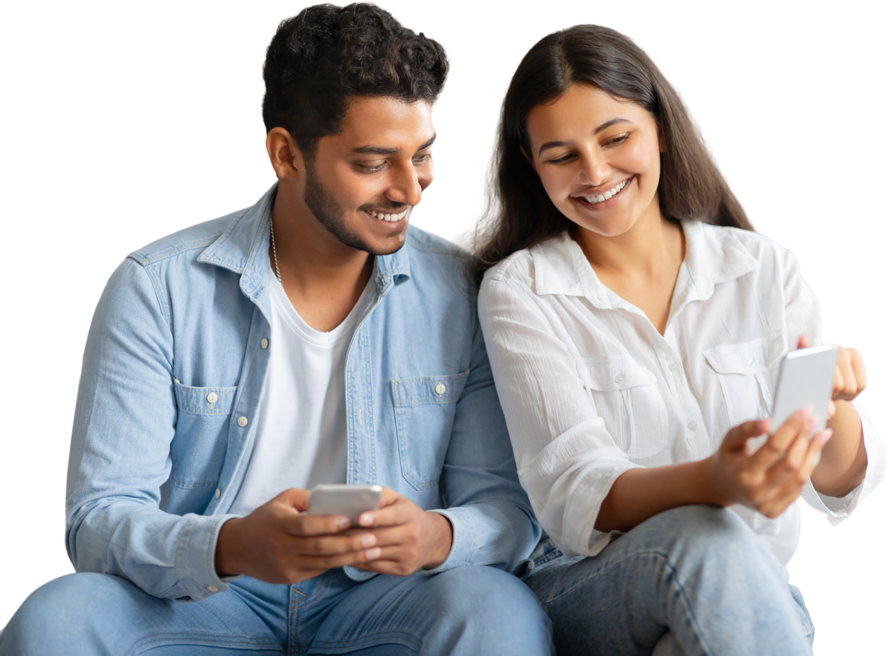 Couple smiling and sitting together looking at their phones